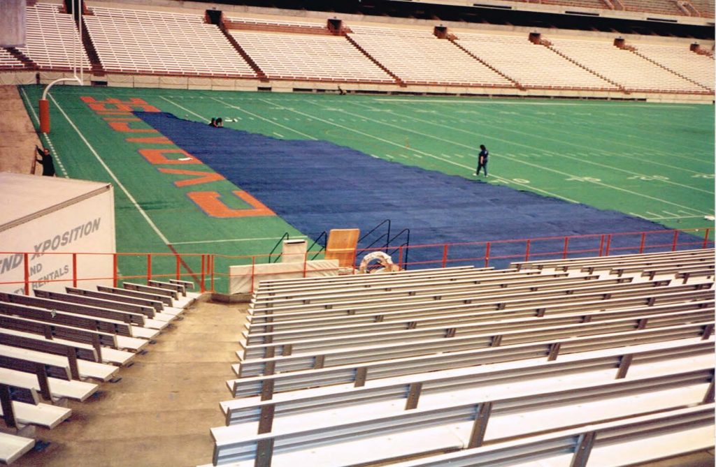 An irregular shaped curtain is laid out on a football field because it was too large to fit in our sewing facilities